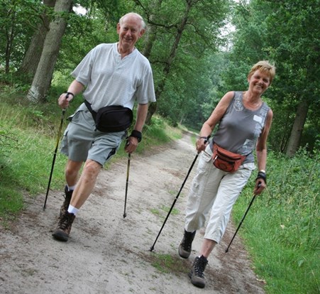 Two seniors enjoying a hike through the woods