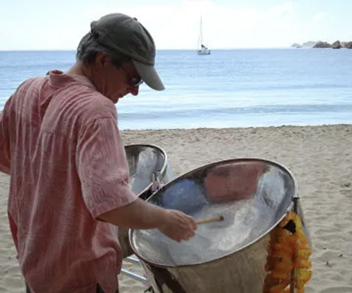 Todd Donnelly playing steel drums on the beach.