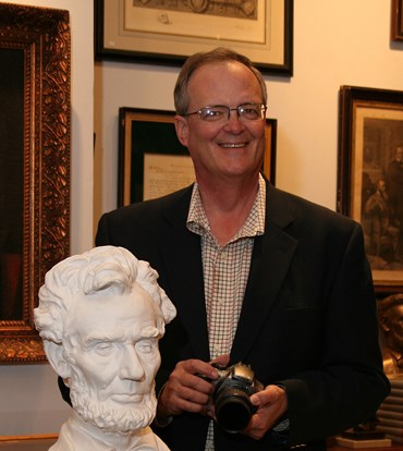 Photographer David Wiegers.standing behind a sculpture of Abraham Lincoln