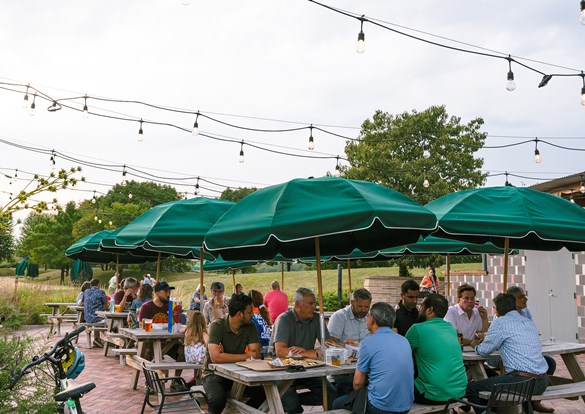 People sitting at picnic tables at the IG Beer Garden