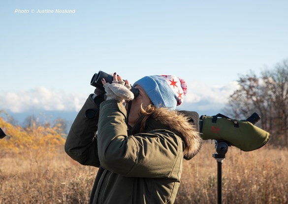 Woman with binoculars looking into the sky