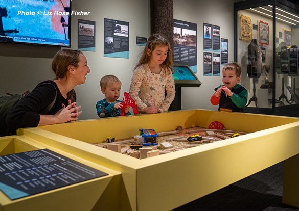 Children playing with a wooden train set during the Sensory-Friendly Hour