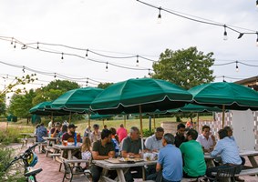 People sitting at picnic tables at the IG Beer Garden