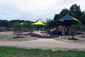 Yellow and green canopies above playground set.