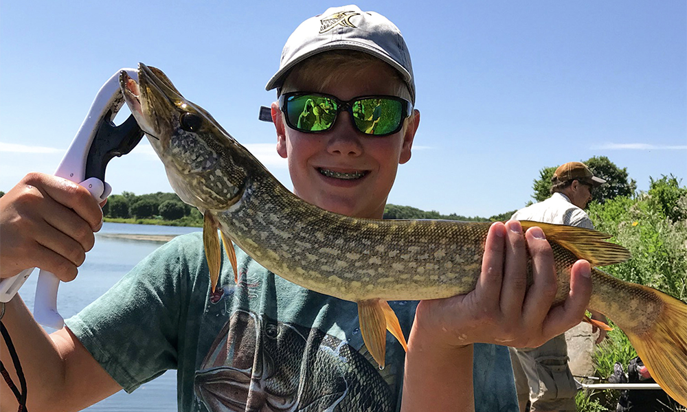 Young boy with big smile after catching a large fish.