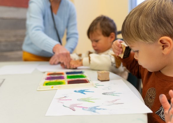 Young boy painting a potting during arts and crafts class