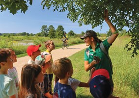Instructor outdoors teaching a group of students about oak trees.