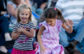 Two little girls happily dancing, capturing a moment of fun and friendship.
