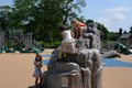 Three young girls rock climbing at a playground.