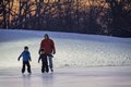 Photo of sun setting over a group of ice skaters