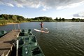 Person on a standing paddle board near a boat dock.
