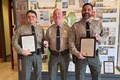 Three police officers receiving an award.