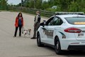 Police officer speaking with a woman and her dog.