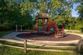 Bright red playground set with slides and castle tower.