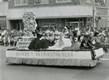 Parade float from 1950's with black, white and hispanic participants on the floAT.