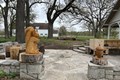 Stone patio with stone retaining wall and a shelter with picnic tables.