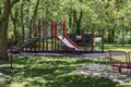 Bright red and green playground set in the woods.