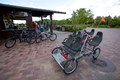 Dual rider bicycle on a cobblestone pathway.