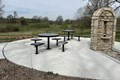 Concrete patio with black metal seats and tables.