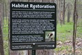 Posted Habitat Restoration area sign listing what will be removed and why.