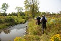 Conservation ecologists walking in a river collecting information on fish species.