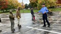 Fireman teaching students how to use a fire extinguisher properly.