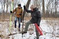 Staff members in the woods measuring and documenting trees locations.