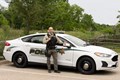 Police officer standing in front of police squad, Lake County Forest Preserve Police.