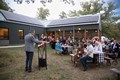 Presenter at a podium talking to a group outdoors.