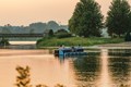 Pedal pontoon boat floating as the sun reflecting off the water.