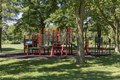 Bright red and green playground set in the woods.