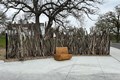 Osage orange fence made sticks, with a wooden bench infrone.