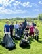ConEx instructors with a group of students out collecting plant cutting in a prairie.
