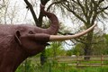 Lifesize mastodon sculpture in a park.