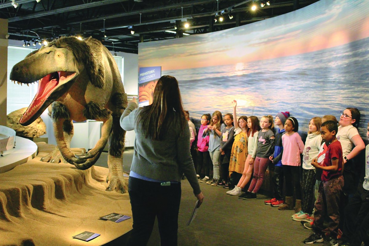 Instructor teaching a classroom of children about dinosaurs
