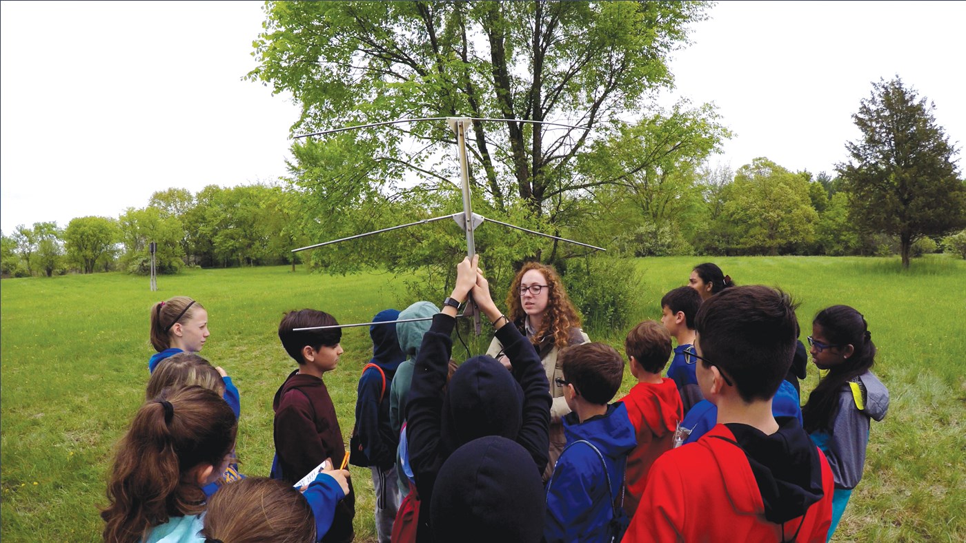 Instructor with a group of children learning how to monitoring wildlife