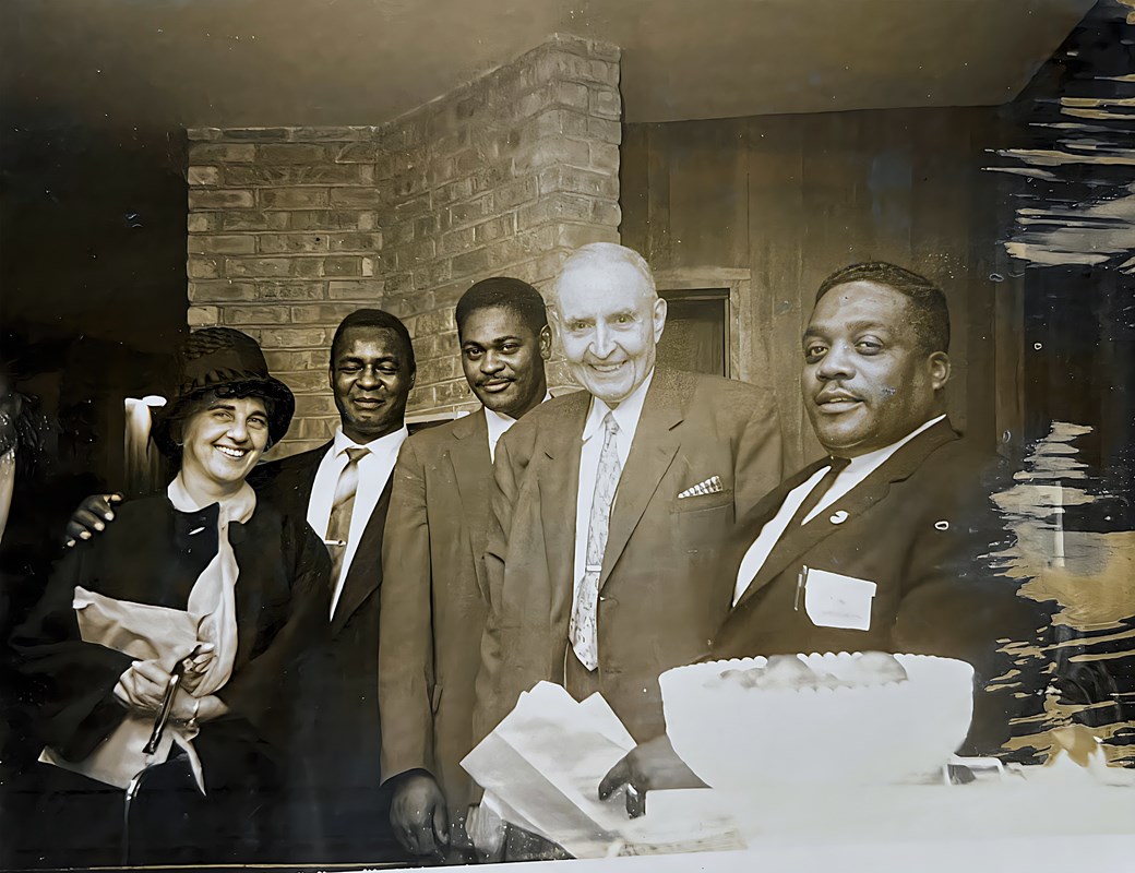 Group of men and women gathering in a room together.