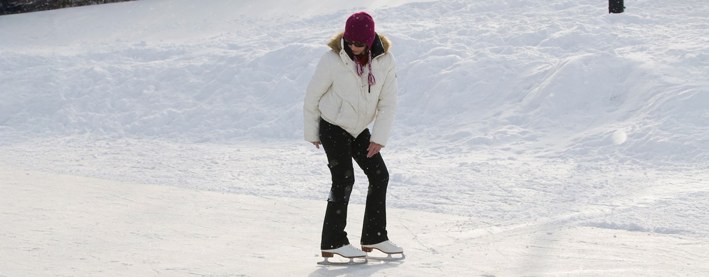 Woman ice skating backwards on the frozen ice rink